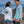 Load image into Gallery viewer, Two people wearing white and marine blue Humu Woody bamboo lightweight hoodies on a rocky shoreline by the ocean.
