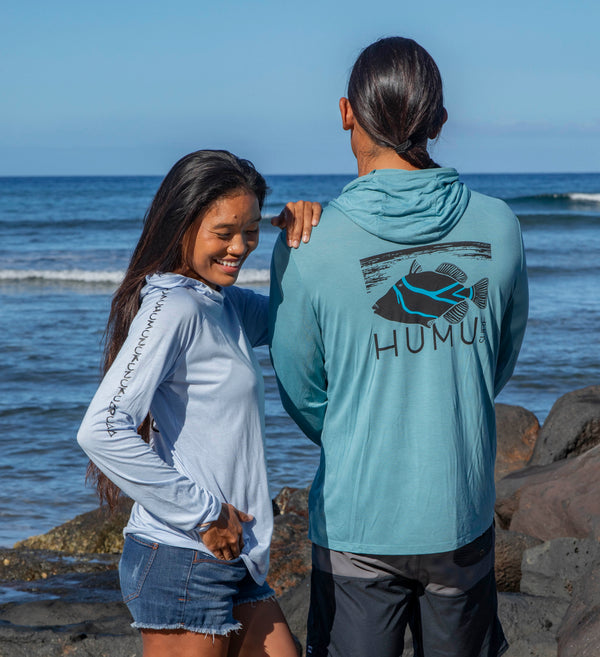 Two people wearing Humu Woody bamboo lightweight hoodies by the ocean.
