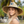 Load image into Gallery viewer, Close-up portrait of a woman wearing the wide-brim Humu Classic Lifeguard Hat with embroidered fish patch
