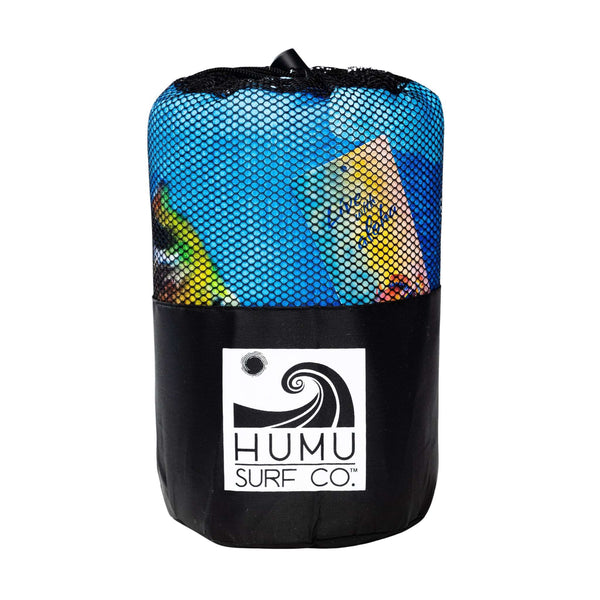 Rolled Humu Surf Live With Aloha microfiber yoga towel inside its black mesh carrying bag with the Humu Surf Co. wave logo on the front
