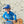 Load image into Gallery viewer, Child wearing the blue Humu Molokini Trucker Hat while holding a ukulele on the beach
