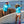 Load image into Gallery viewer, Two women in blue Humu Wahine Kore-Dry Long Sleeve Rashguards with paddleboards, wearing a Napili Trucker Hat and Classic Lifeguard Hat
