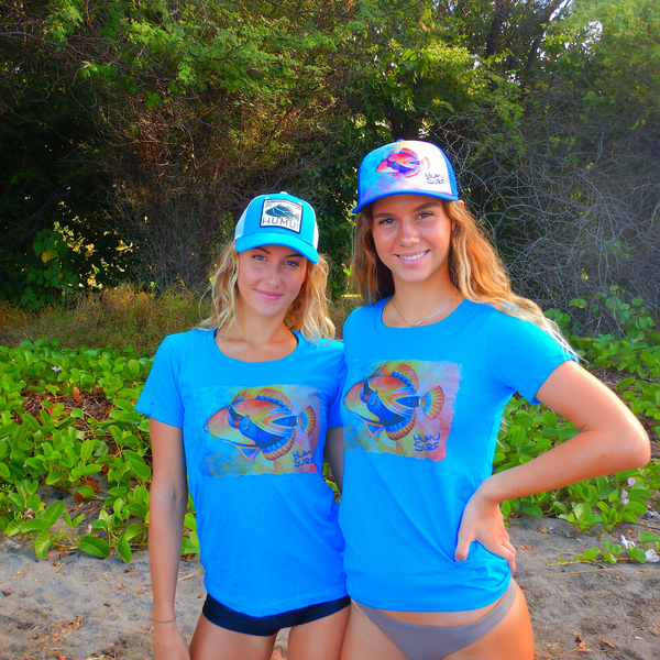Two women wearing blue Humu Women's Honolua Short-Sleeve T-Shirts with Molokini and Napili Trucker Hats