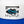 Load image into Gallery viewer, Close-up of the Humu Surf fish logo on the white front panel of the royal blue Original Trucker Hat
