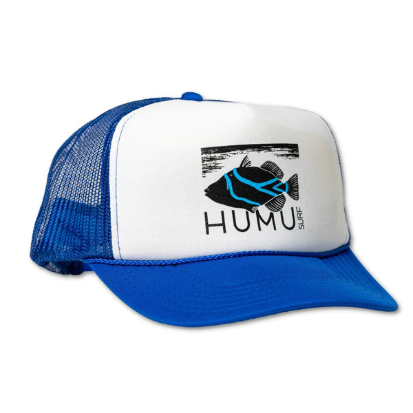 Three-quarter view of the Humu Original Trucker Hat in royal blue and white with Humu Surf fish logo and blue mesh back