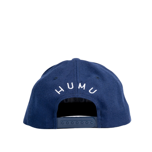 Back view of the navy Humu Wave Snapback Cap with Humu lettering above the adjustable snap closure